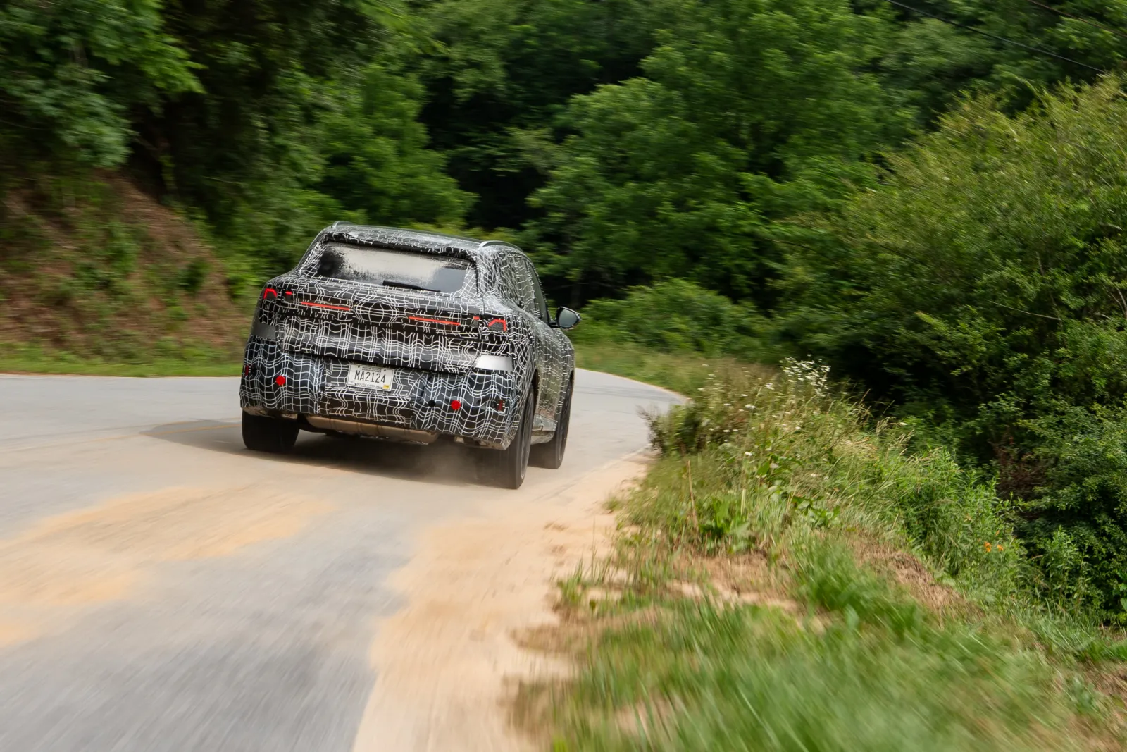 Nieuwe BMW X5 prototype in camouflage tijdens testrit, achterkant