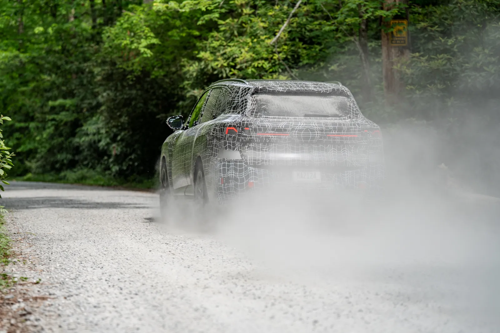 Nieuwe BMW X5 prototype rijdend op grindweg