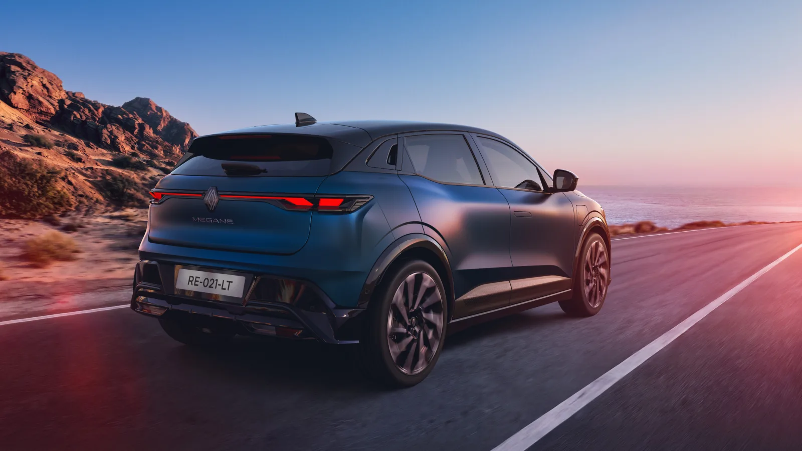 Nieuwe Renault Megane E-Tech electric achterkant rijdend langs de kust